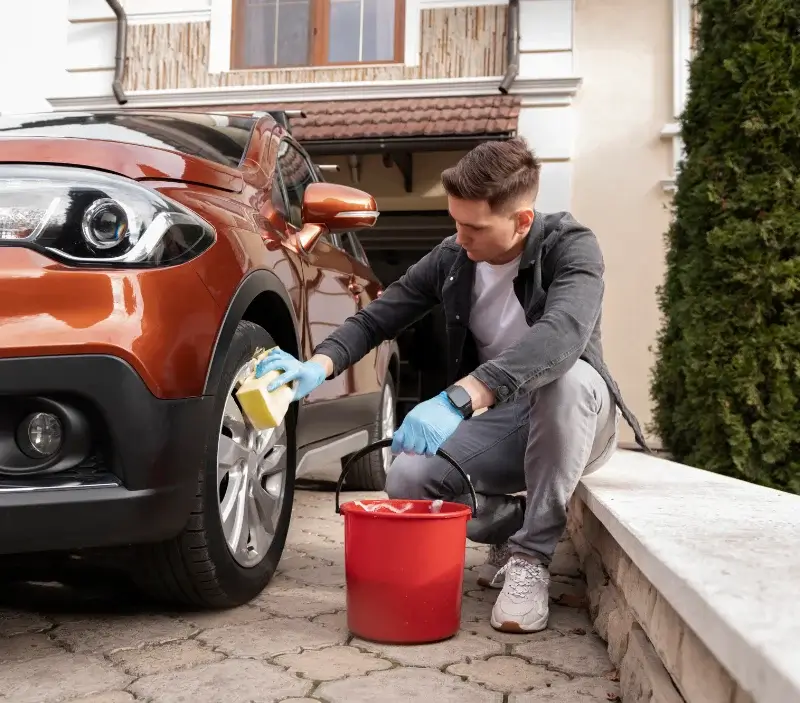 Lavage auto à domicile Bâgé-le-Châtel : professionnel intervenant sur un véhicule